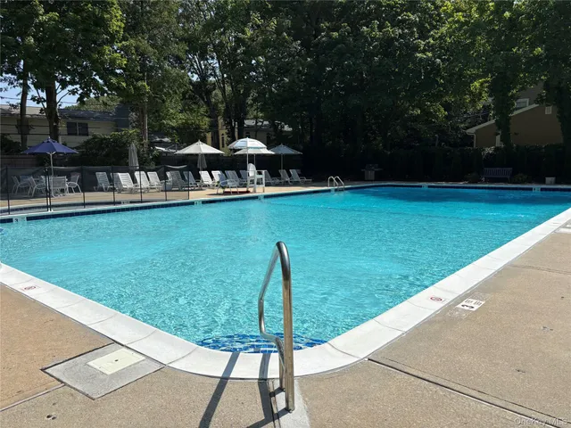 a view of a swimming pool with a patio and a yard