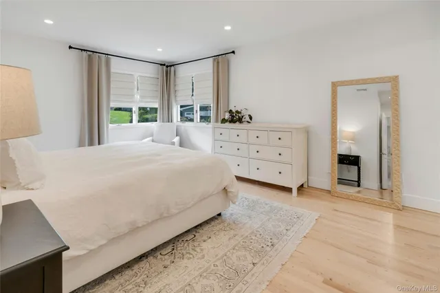 a spacious bedroom with a large bed and a dresser