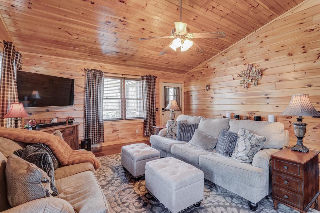 388 Cozy Cove Road Blairsville, GA 30512 - Photo 5 of 44 a living room with furniture a flat screen tv and a chandelier