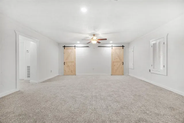 a view of empty room with windows and ceiling fan