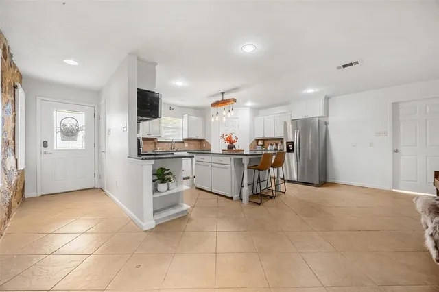 a kitchen with stainless steel appliances kitchen island granite countertop a refrigerator and cabinets