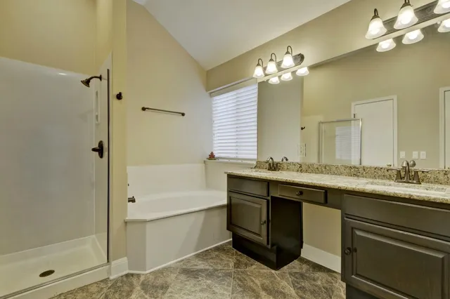 a bathroom with a double vanity sink mirror and shower