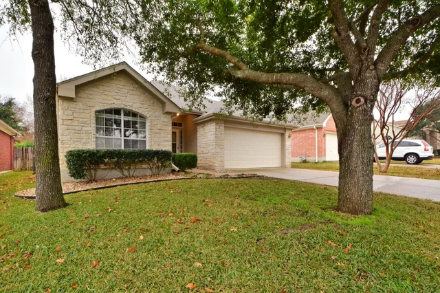 a view of a house with backyard and tree