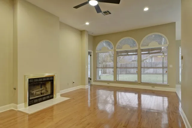 a view of an empty room with a fireplace and a window
