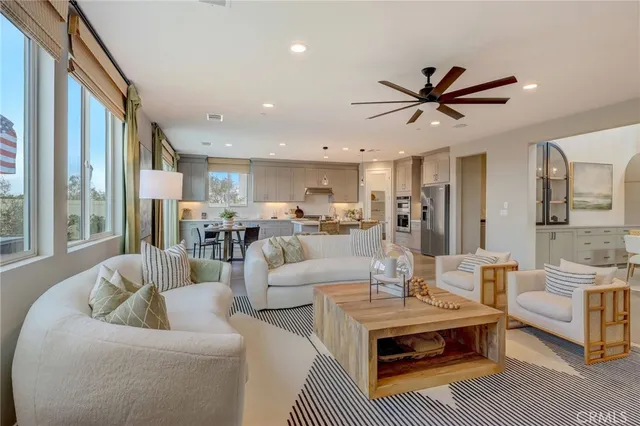 a living room with furniture and a view of kitchen
