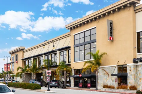 a front view of a building with parking area