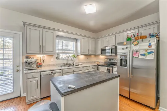 a kitchen with stainless steel appliances granite countertop a refrigerator and a sink