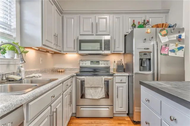 a kitchen with stainless steel appliances granite countertop a sink stove and refrigerator