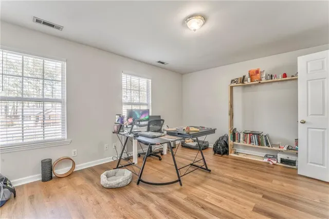 a work room with furniture a rug and a window