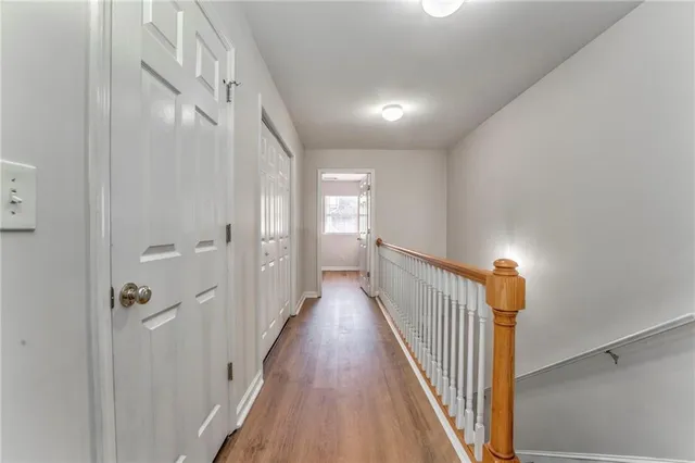 a view of a hallway with wooden floor and staircase