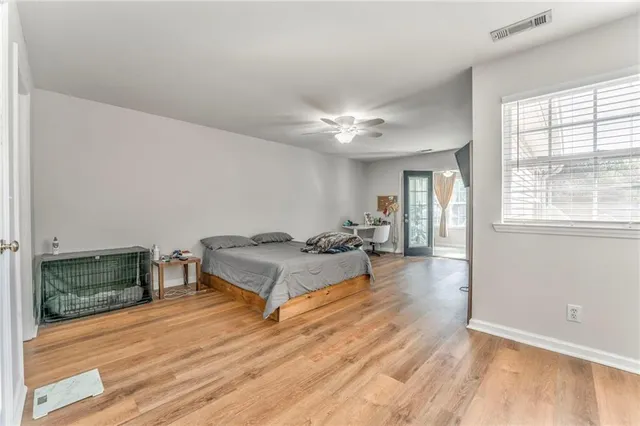 an empty room with wooden floor and window