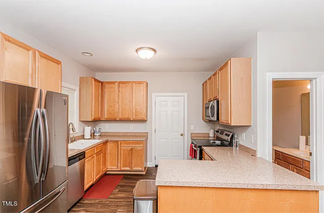 a kitchen with stainless steel appliances granite countertop a refrigerator sink and stove