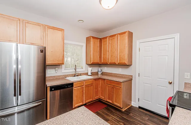 a kitchen with stainless steel appliances a sink cabinets and a window