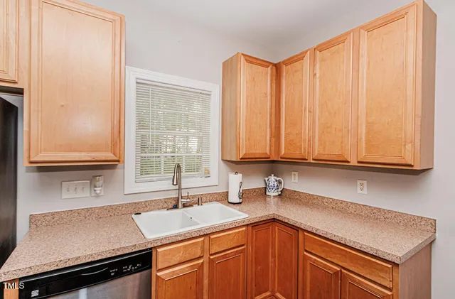 a kitchen with a sink cabinets and window