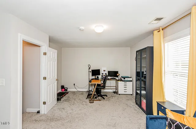 a view of a workspace with furniture and a window