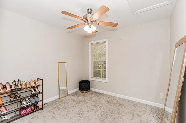 an empty room with windows and ceiling fan