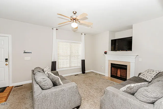 a living room with furniture a fireplace and a flat screen tv