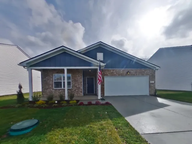 a front view of a house with a garden and yard