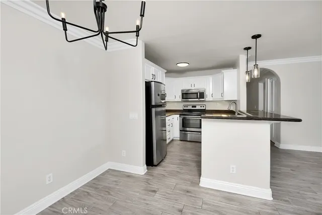 a kitchen with stainless steel appliances granite countertop a refrigerator a stove top oven and sink