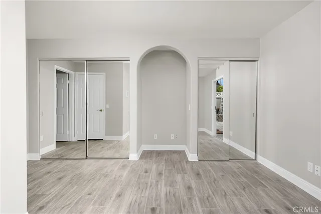 an empty room with closet and wooden floor