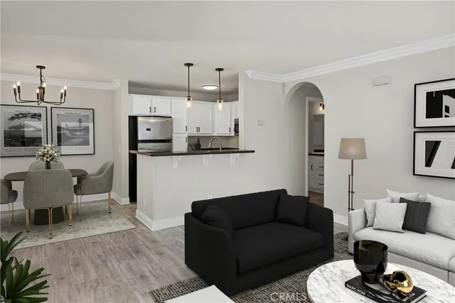 a living room with furniture a flat screen tv and kitchen view