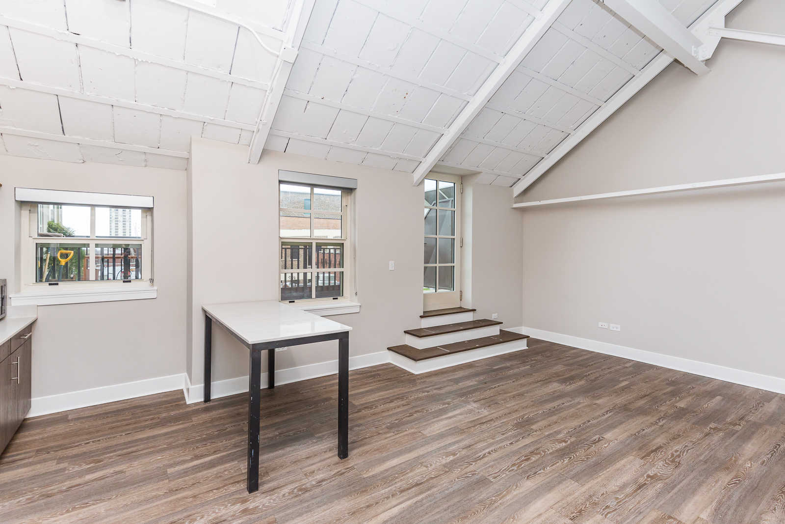 Undisclosed Address Chicago, IL 60640 - Photo 2 of 9 a room with lots of wooden furniture and windows