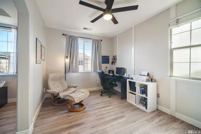 a living room with furniture a window and wooden floor