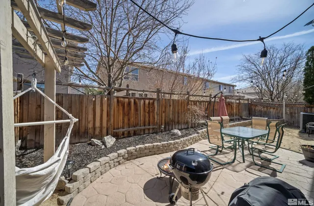 a backyard of a house with chairs and table in it