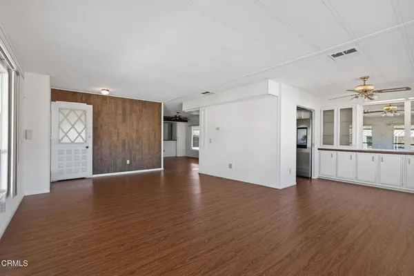 a view of a big room with wooden floor and windows
