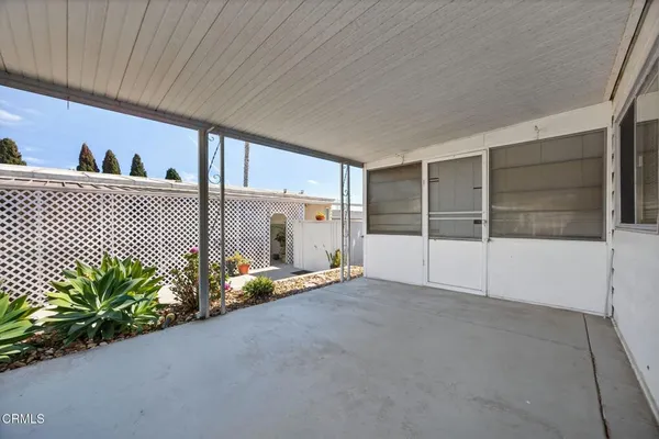 a view of a porch with furniture and a yard