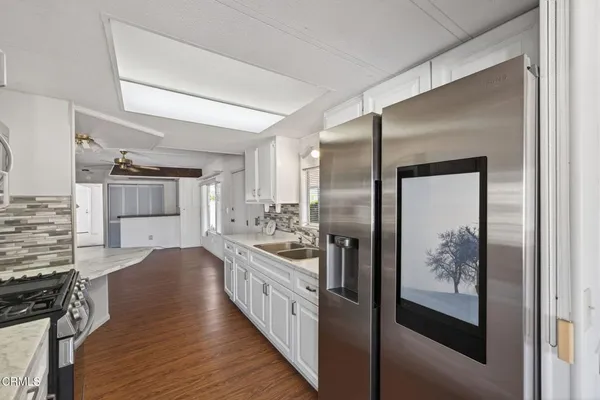 a kitchen with stainless steel appliances granite countertop a refrigerator and a stove