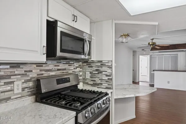 a kitchen with granite countertop a stove and a microwave