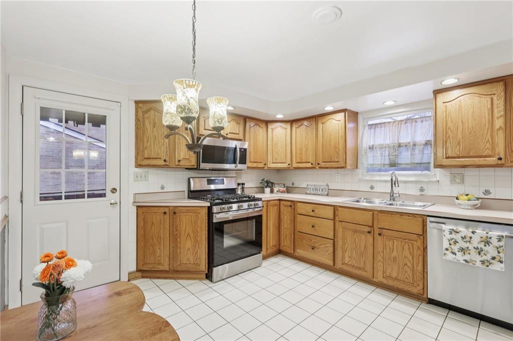 631 George Street Turtle Creek, PA 15145 - Photo 14 of 44 a kitchen with stainless steel appliances granite countertop a stove sink and cabinets