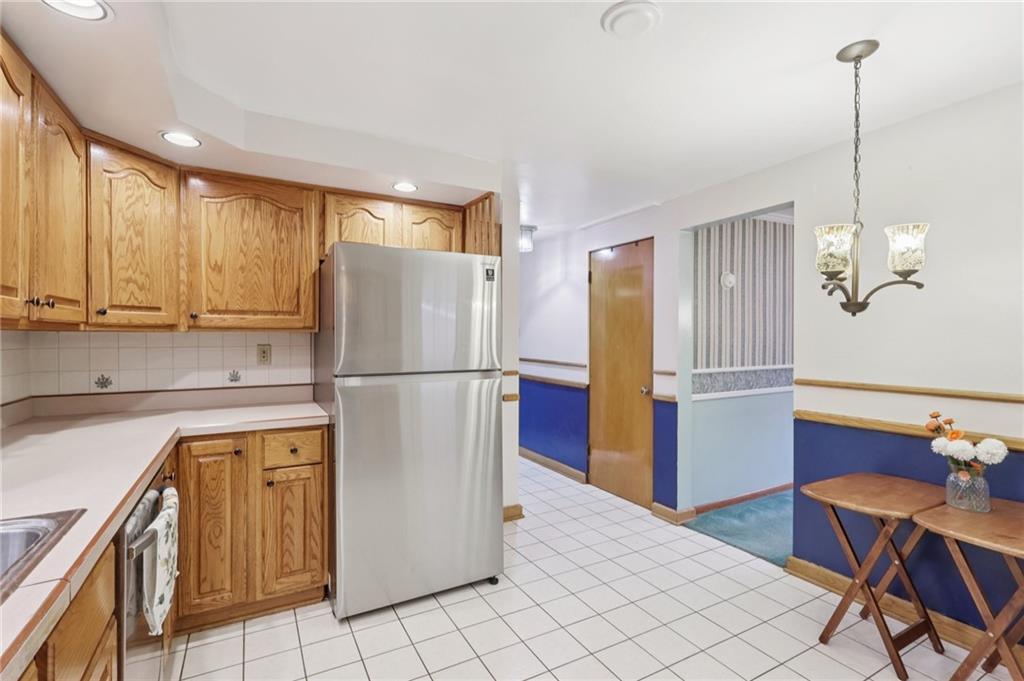 631 George Street Turtle Creek, PA 15145 - Photo 16 of 44 a kitchen with stainless steel appliances granite countertop a refrigerator a sink a stove a dining table and chairs