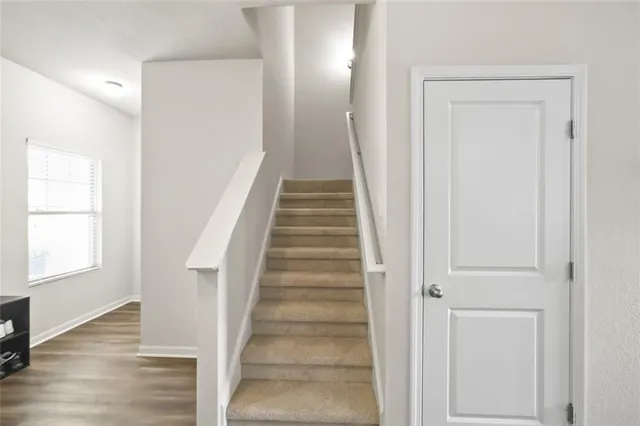 a view of a hallway with wooden floor and entryway