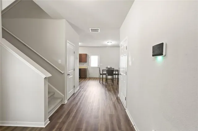 a view of a hallway with wooden floor and furniture