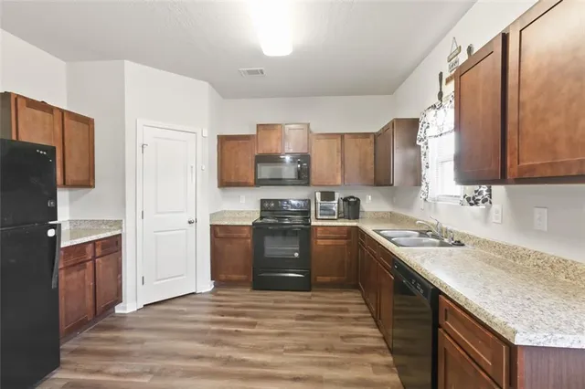a kitchen with stainless steel appliances granite countertop a refrigerator stove and sink