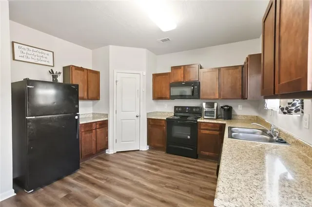a kitchen with granite countertop a refrigerator stove and oven