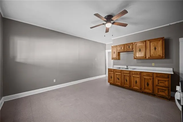 a view of an empty room with window and a ceiling fan