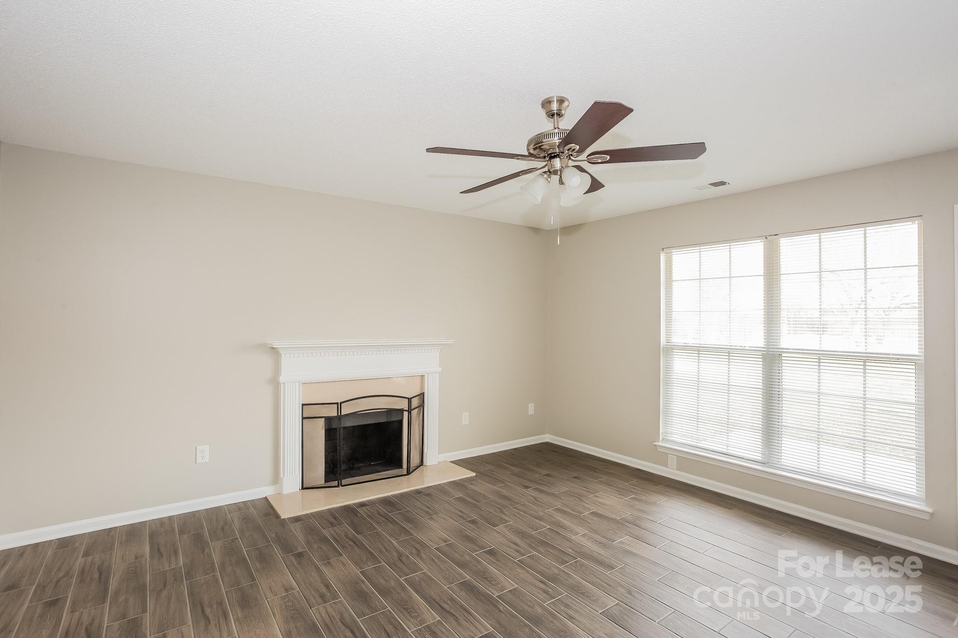 14319 Ruddy Court Charlotte, NC 28273 - Photo 4 of 16 a view of an empty room with a fireplace and a window