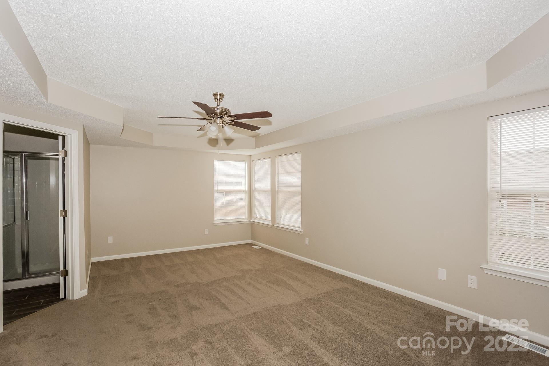 14319 Ruddy Court Charlotte, NC 28273 - Photo 6 of 16 an empty room with windows and fan