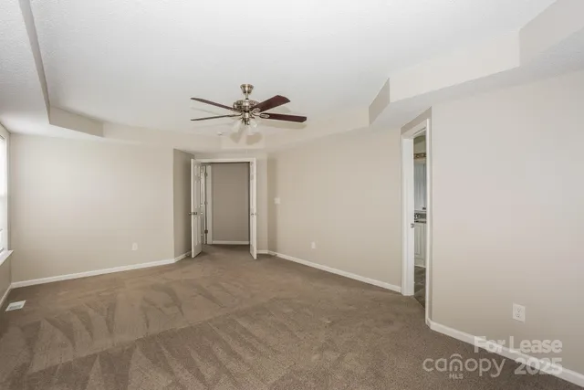 a view of an empty room with a ceiling fan