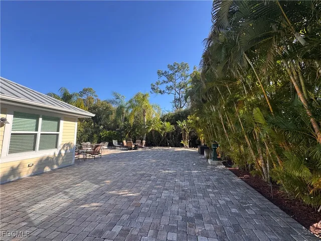 a view of a patio with table and chairs with wooden floor and fence