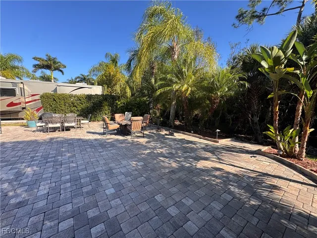a palm tree sitting in front of a house with a big yard