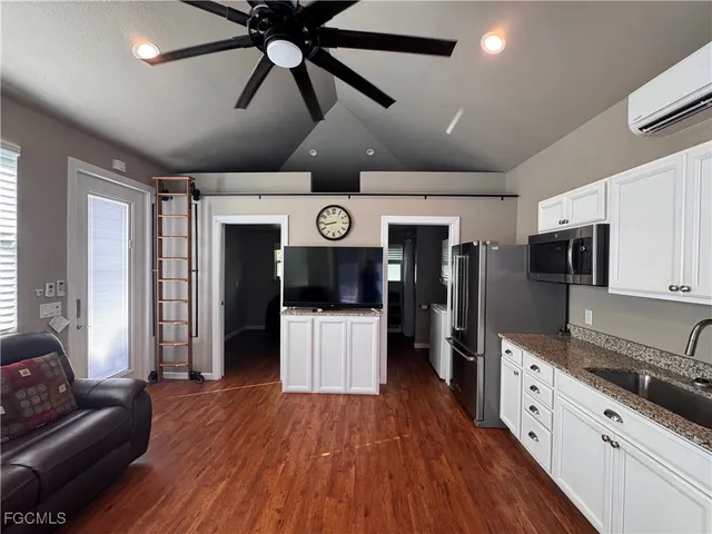 a large white kitchen with lots of counter space and wooden floor