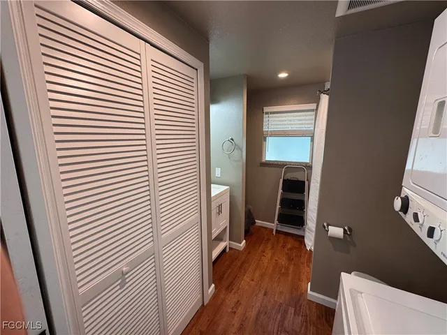 a view of hallway with wooden floor and electronic appliances