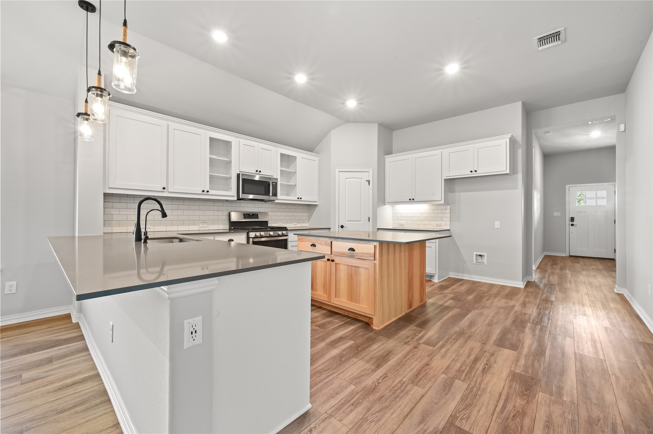 426 Cold Riv Run Kyle, TX 78640 - Photo 11 of 34 A well-lit kitchen with sleek countertops and rich wood flooring defines this contemporary living space.