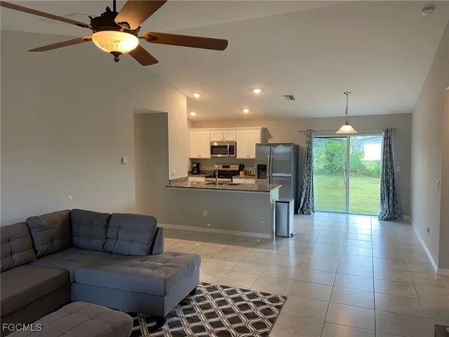 a living room with kitchen island furniture and a ceiling fan
