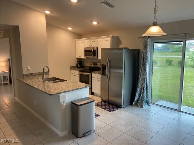 a kitchen with stainless steel appliances granite countertop a refrigerator and a sink