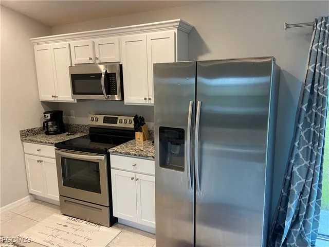 a kitchen with stainless steel appliances cabinets a washer and a refrigerator